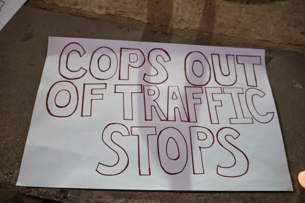 Protest sign on the ground that reads "cops out of traffic stops."