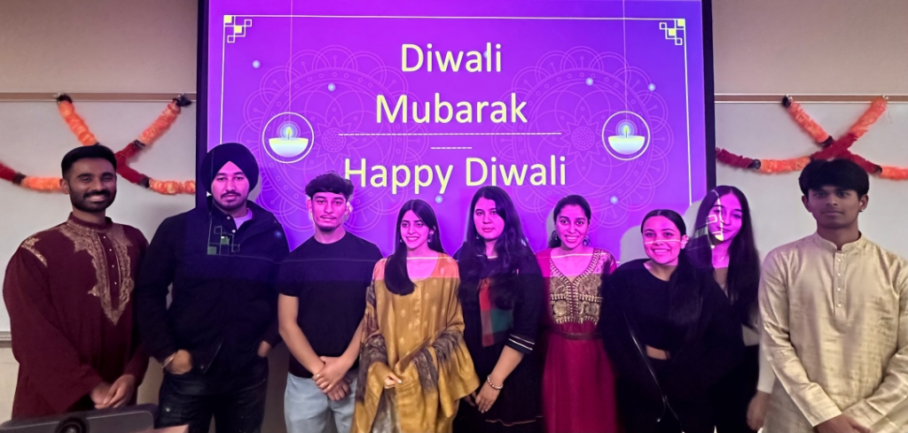 Chabot College South Asian/Punjabi club members pictured under a Happy Diwali sign.