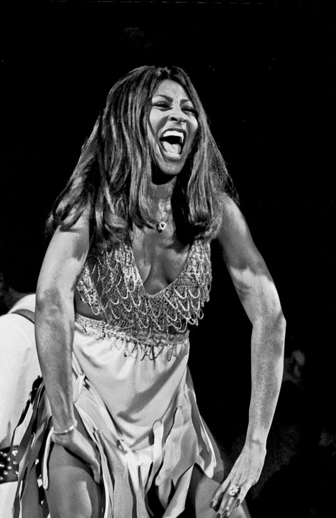 Tina Turner, a legendary singer and performer, captivating the audience with her powerful voice and electrifying stage presence.