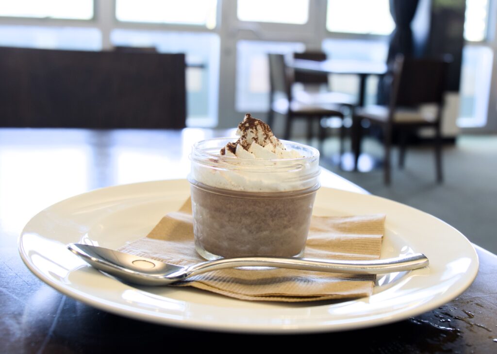 Chocolate and coffee panna cotta topped with whipped cream and cocoa nibs